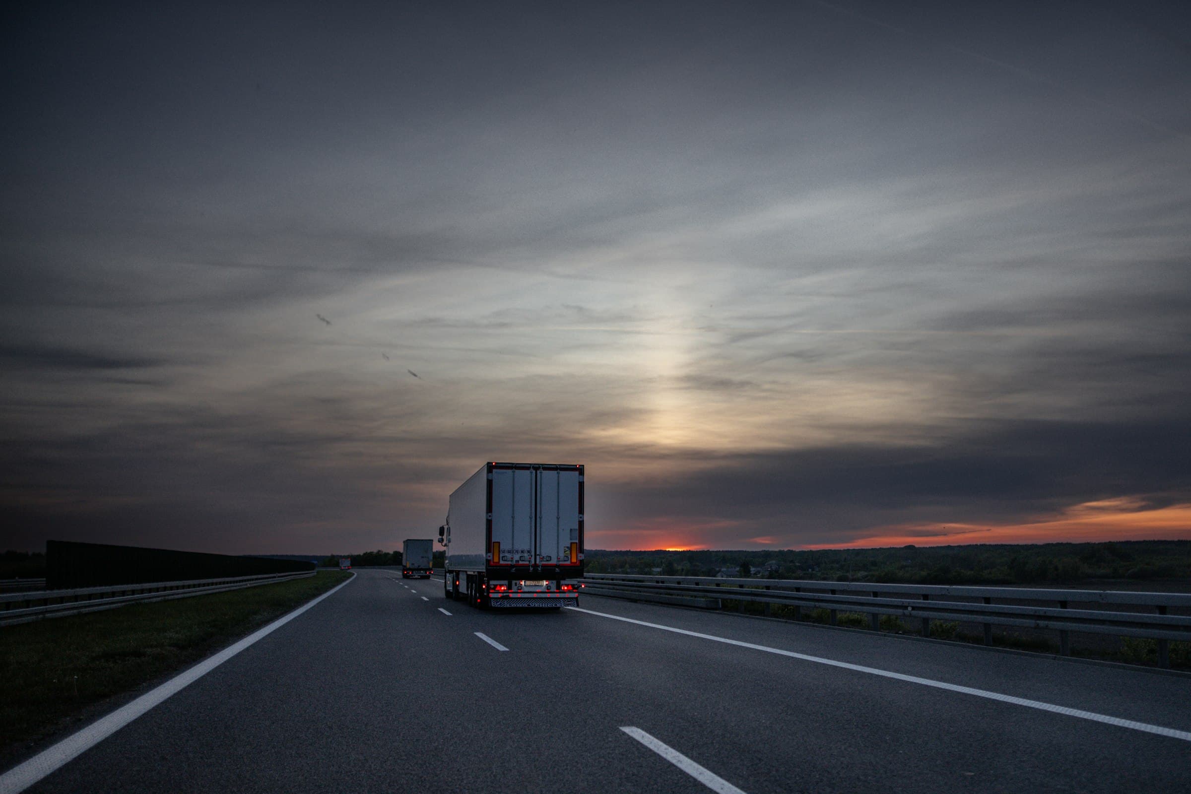 Trucks on a highway at sunset